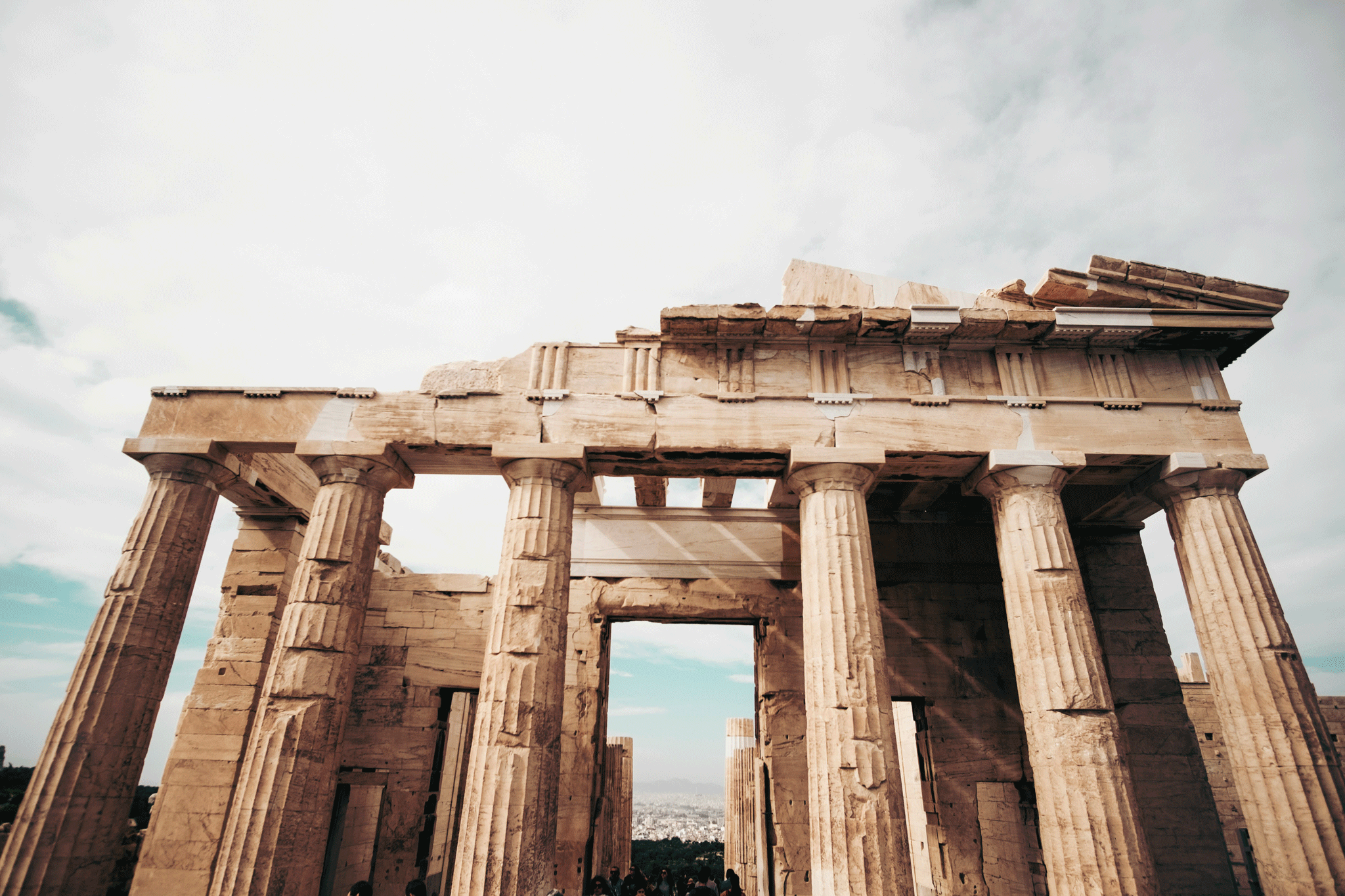 Close-up view of the Parthenon in Athens, Greece, highlighting its majestic ancient columns against a cloudy sky backdrop.